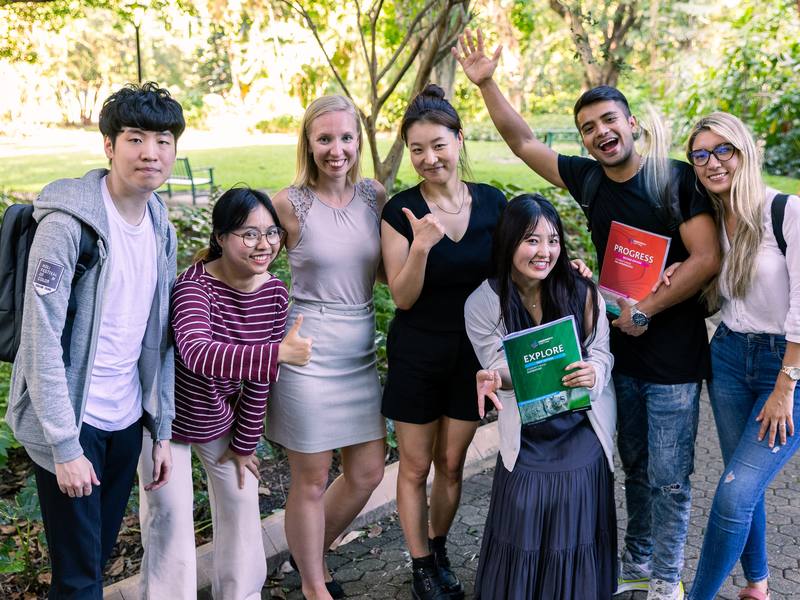 Greenwich College の学生たち。屋外で学校の教材を手にしている